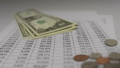 Coin and Banknotes with Financial Data Animation On White Paper Stock Footage 119618646