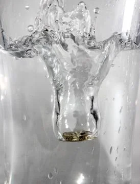 Coin causing a splash Stock Photos