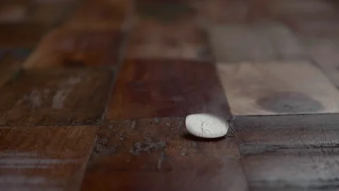 Coin Drop On Wooden Floor Showing Tails. close up