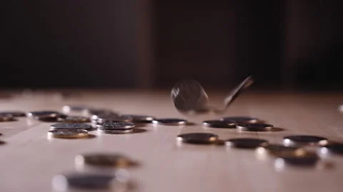 A coin falling on a wooden surface Stock Footage 152419051