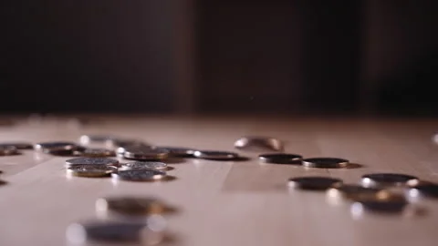 A coin falling on a wooden surface Stock Footage 152419071