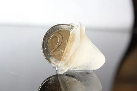 Coin in ice cube Stock Photos