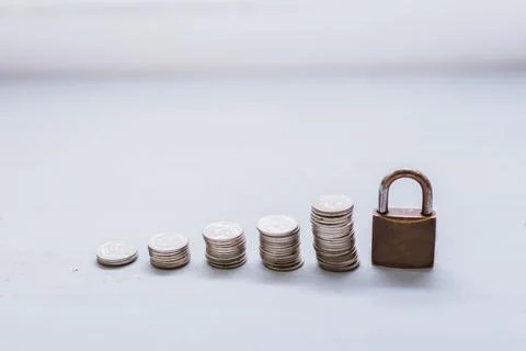 Coin money stack and lock, on gray background. Saving and financial security  Stock Photos