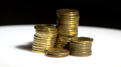 Coin piles spinning on black background Stock Footage 60055992