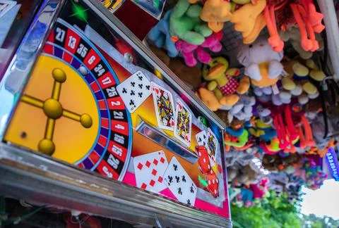 Coin pusher machine featuring a deck of cards Stock Photos