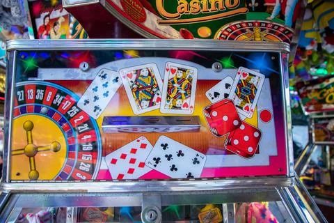 Coin pusher machine featuring a deck of cards Stock Photos