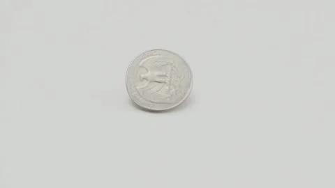 Coin rotates on white surface and falls flat Stock-Footage 265879803