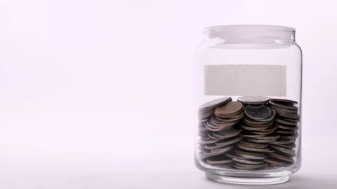 Coin in saving jar with empty label - Stop motion Stock Footage 142266858
