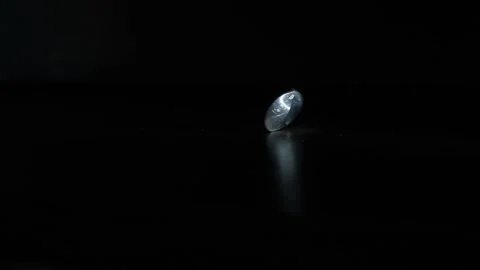 The coin is spinning on a black surface Stock Footage 156697099