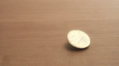 Coin spinning on a table Stock Footage 39582884