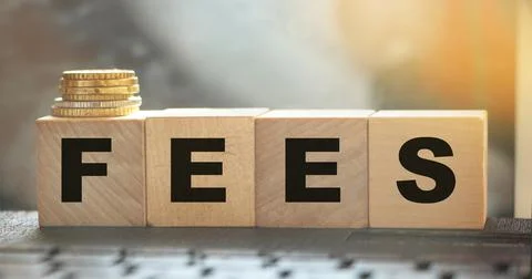 Coin stack and wooden blocks with the fee text. Fee Finance and Money concept Stockfoto's