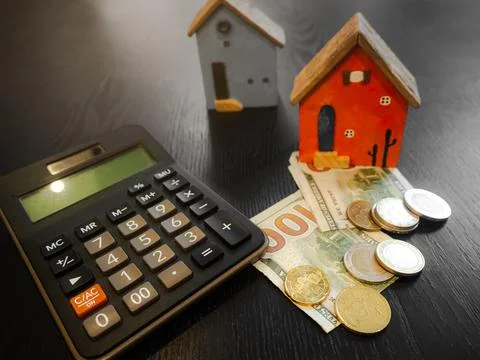 Coin stack on calculator with model house, business finance investment Foto stock