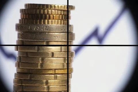 Coin stack with rising chart line, being aimed by a cross-sight sniper scope Stockfoto's