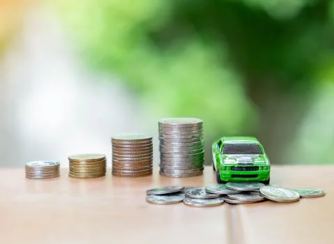 Coin stack is sign saving money for car loan on out of focus background. Stock Photos