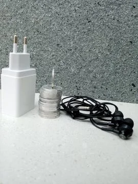 Coin Stack with Standing Coin, Upright Charger Head, and Wired Headset 스톡 사진