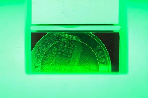 Coin under green scanner light Stock Photos