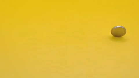 Coin on a yellow background Video stock 333925882