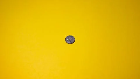 Coin on a yellow background.  Stock Photos