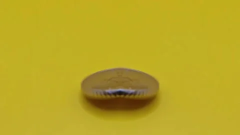 Coin on a yellow surface, mirror reflection Video stock 333915129