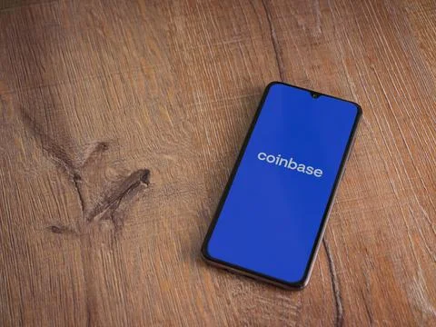 Coinbase app launch screen on smartphone on wooden background Stock Photos