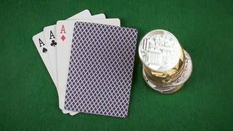 The coins and bitcoins are falling next to the cards on the table top view slow Video stock 85642365
