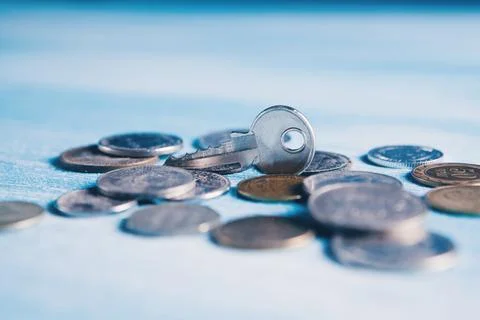 Coins and key on the table Stock Photos