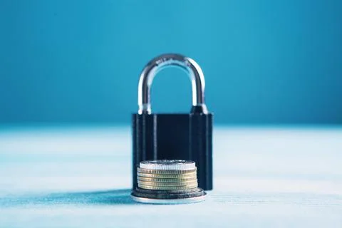 Coins and lock on the table Stock Photos