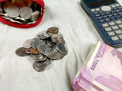 Coins and notes counting or calculation by calculator on white background Stock Photos