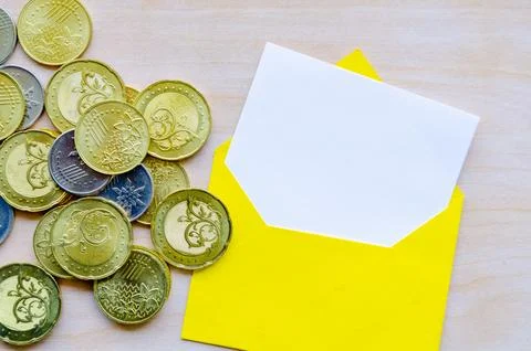 Coins and white notepad in an envelope with customizable space for text or .. Stock Photos