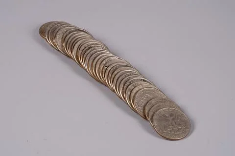 Coins arranged in a line on a flat surface in indoor light 写真素材