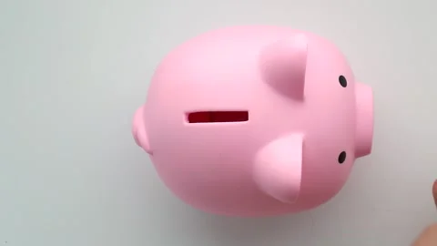 Coins Being Inserted Into Pink Ceramic Piggy Bank Видео 314614611