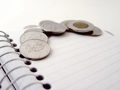 Coins on book Stock Photos