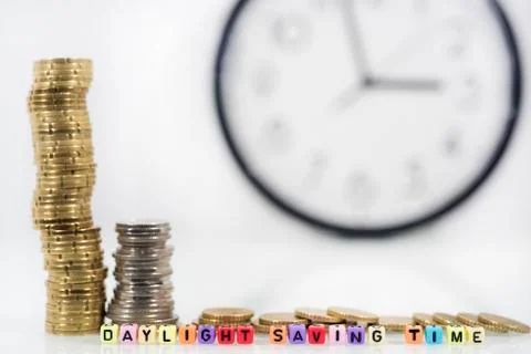 Coins with clock on white table. Summer Daylight Saving Time (DST). Turn time Stock Photos