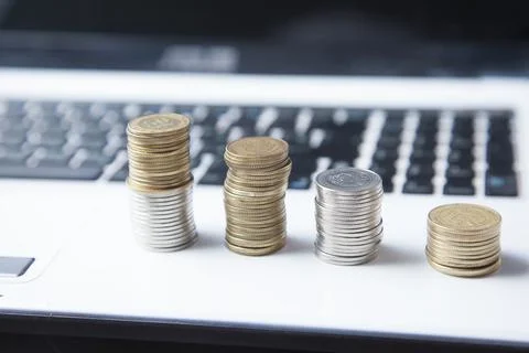 Coins on computer keyboard in office table Stock Photos