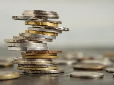 The coins of different countries are stacked on top of each other in differen Stock Photos