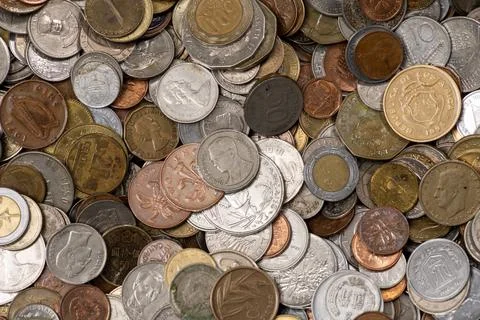 Coins from different countries background. Coins show mixed metal textures an Stock Photos