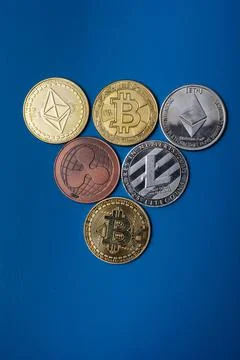 Coins of different cryptocurrencies on a blue background modern economy. Stock Photos