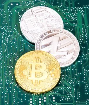Coins of digital cryptocurrency lying over electronic computer component. Bus Stock Photos