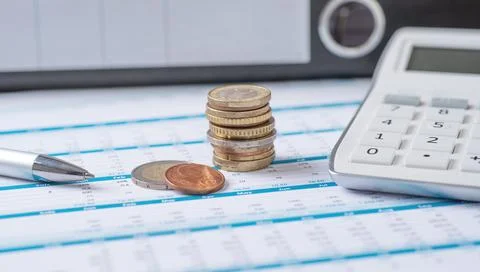 Coins on documents with a calculator Стоковые фото