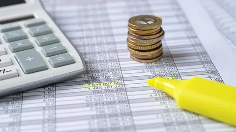 Coins on documents with a calculator Stock Photos