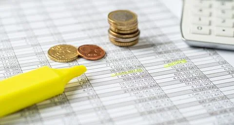 Coins on documents with a calculator 스톡 사진