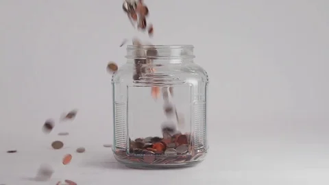 Coins Fall into Clear Jar in Slow Motion Stock Footage 74959173