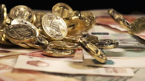 Coins fall on the notes and turn in slow motion Stock Footage 64570363