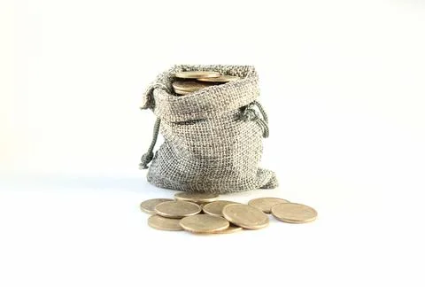 Coins fall out of a burlap sack canvas bag on white background Stock Photos