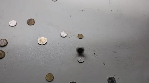 Coins falling and scattering on a textured surface in slow motion Stock Footage 339181108