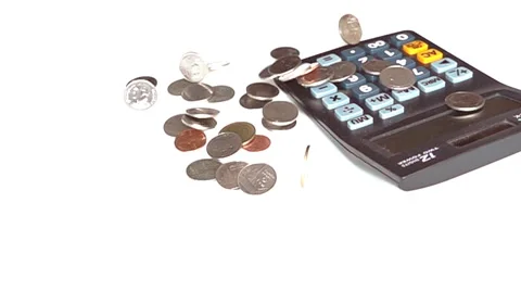 Coins  falling down on white background with calculator, slow motion. 库存影片 64570457
