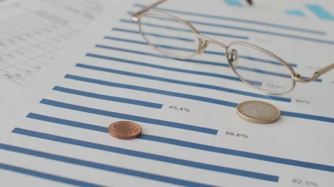 Coins Falling on Financial Documents and Charts Stock Footage 172314657