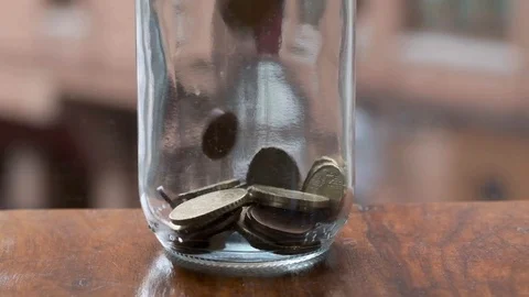 Coins falling into jar - slow motion Stock Footage 116469701