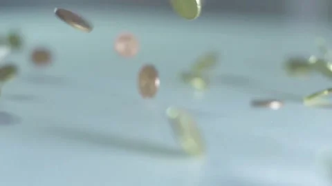Coins falling in slow motion and bouncing on clear surface close up. 스톡 동영상 336335502