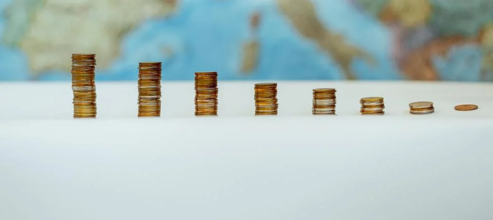 Coins in the form of a falling chart on a background of a map of Europe Stock Photos